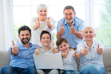 Family with laptop showing thumbs up
