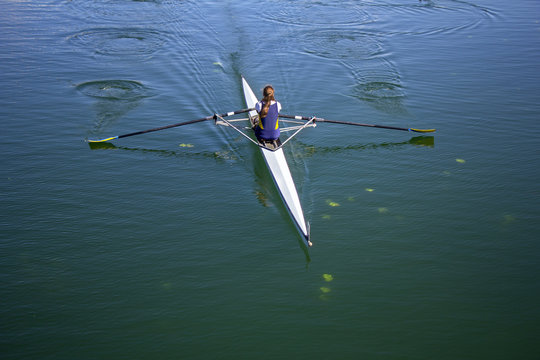 Young woman rowing in boat on the lake