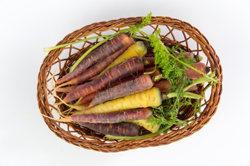 Obraz premium vegetable colorful carrots in a bamboo basket isolated on white background