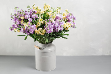 Bouquet of lilac and lemon color flowers gillyflower in grey water can