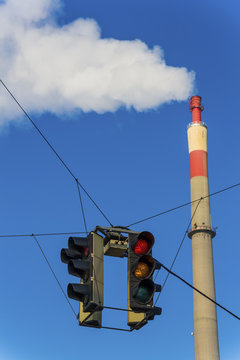 industrial chimney and red traffic light