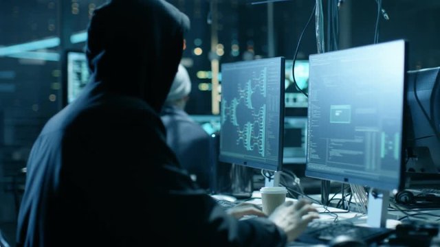 Group of Hacktivists Organize Massive Data Breach Attack on Corporate Servers. They're in Underground Secret Location Surrounded by Displays and Cables. Shot on RED EPIC-W 8K Helium Cinema Camera.