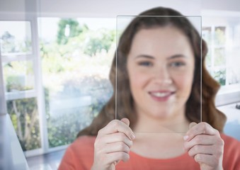 Woman holding glass screen by sunny window