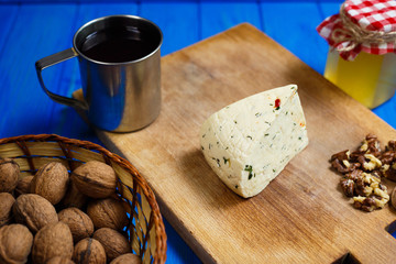 Piece of homemade spicy cheese with walnuts,mug of homemade wine and honey