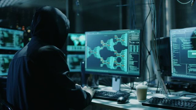  Hooded Hacker Breaks into Corporate Data Servers and Infects them with Virus. His Hideout Place has Dark Atmosphere, Multiple Displays, Cables Everywhere. Shot on RED EPIC-W 8K Helium Cinema Camera.