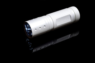 White flashlight on mirrored black background