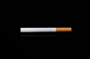 Cigarette on mirrored black background