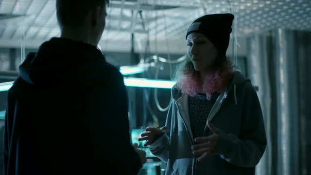 Teenage Boy and Girl Plan Malware Attack on Government Servers. In the Background Dark Place with Neon Lights and Displays.Shot on RED EPIC-W 8K Helium Cinema Camera.