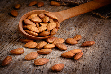 Almonds on textured wooden background. Peeled nuts. Organic food.