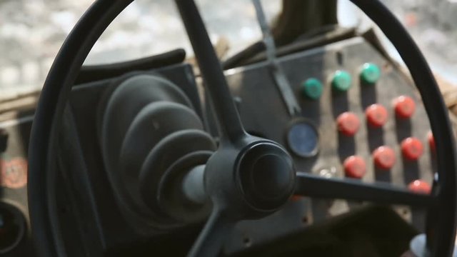 Retro bulldozer working. Close-up hands and steering wheel
