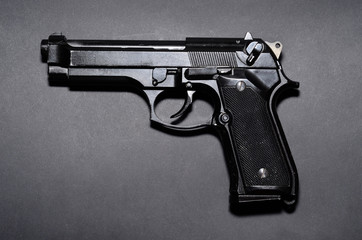 Used black metal 9mm pistol gun on black background