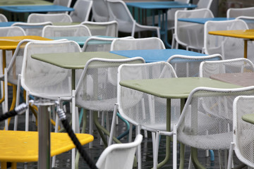the Restaurant zone with colorful plastic chairs and blue, yellow, white tables in the lobby of the mall. Beautiful interior