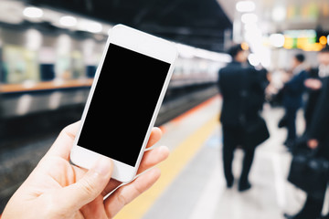 Blank screen of smartphone in hand at train station