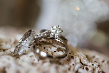 diamond wedding rings with engraving on beige background