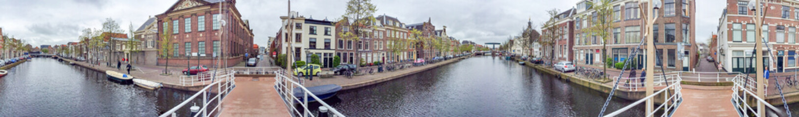 AMSTERDAM - APRIL 2015: Tourists walk along city canals. The city attracts 15 million people...