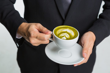 hands of businessman holding a cup of coffee or green tea