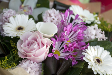 Pink-white bouquet of rose, calla, hyacinth, gerbera in kraft paper
