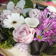 Pink-white bouquet of rose, calla, hyacinth, gerbera in kraft paper