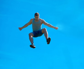 Fototapeta na wymiar Jumping up guy. Background blue sky.