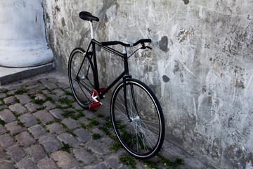 Obraz na płótnie Canvas black hipster bicycle near the grey concrete wall