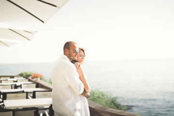 Happy romantic fashion couple in love have fun on beautiful sea at summer day