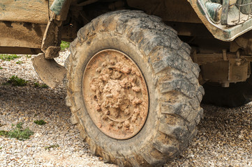 Fototapeta na wymiar Muddy grunge tyre wheel of heavy duty truck closeup