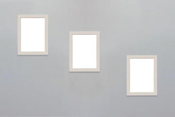 Three picture frames on the concrete wall.