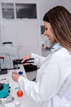 Woman scientist carrying out experiment in research laboratory