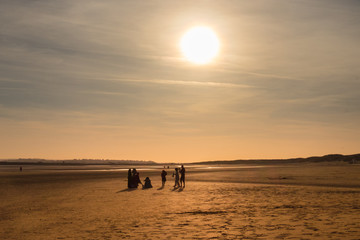 Silhouette of a family on Camber Sands beach at sunset in spring, East Sussex, England