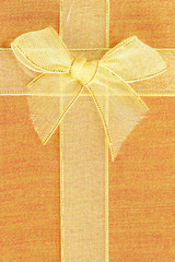 Gift box top view with gold ribbon and bow