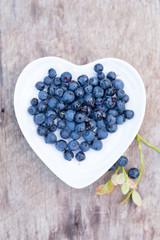 forest blueberries heart plate wooden background
