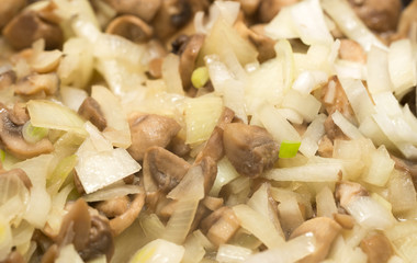 Mushrooms with onions are fried in a frying pan