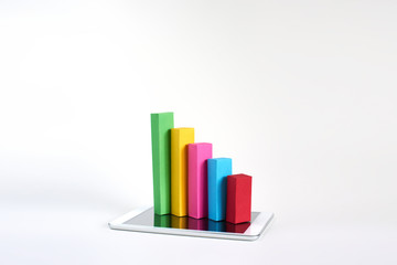 Charts made of colourful paper presenting diagram concept in real life on the tablet