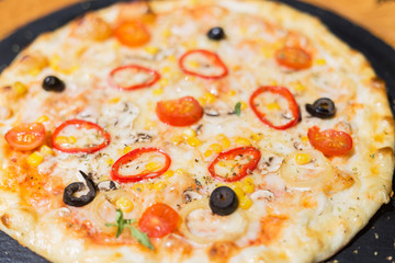 Vegetarian meatless pizza on a dark background with mushrooms, cheese and sweet pepper.  