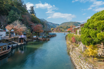 Fototapeta na wymiar Boats over Nishiki river in Iwakuni, Yamaguchi prefecture, Beautiful valley with seasonal colorful trees and blue sky landscape in Japan.