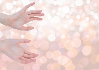Hands open delicately with sparkling light bokeh background