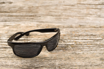 Men's fashion sunglasses on a wooden background 
