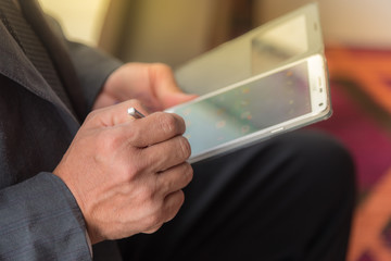 Hand holding mobile phone and stylus to connect business.