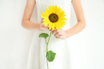 Girl holding sunflower on white background