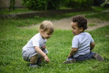 Naklejka na ściany i meble toddler boys playing outside, multi racial friendship
