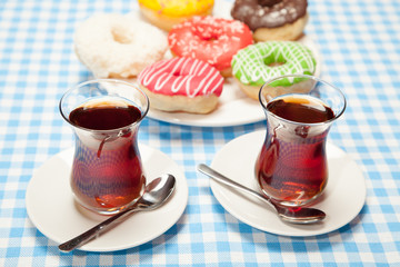 Two cups of tea and donuts on a blue table