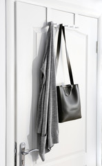 Hanging clothes on door in modern hall interior