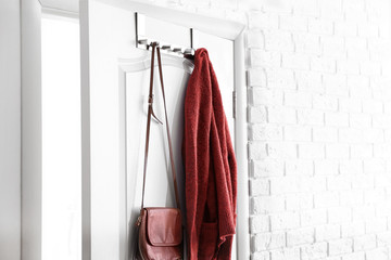 Hanging clothes on door in modern hall interior