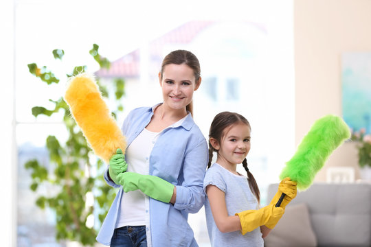 Mother and daughter with cleaning tools at home