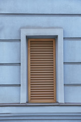 Window with closed blinds on old blue building