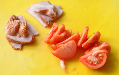 bacon and tomato ingredients on a yellow cutting board