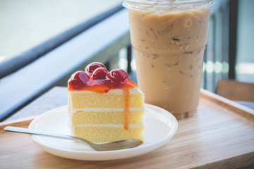 Sponge cake with cherry syrup. Peace of cherry cake serve with iced coffee