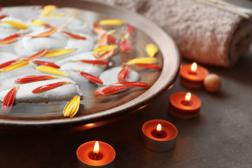 Beautiful spa composition with flower petals on water