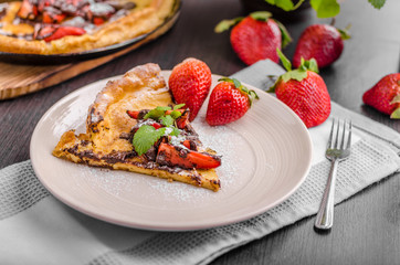 Pancake in oven, dutch baby pancake with strawberries