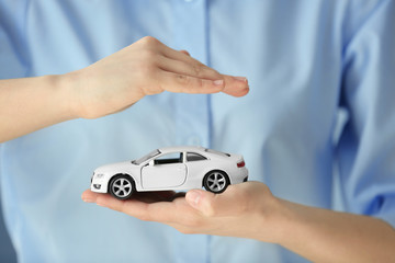 Travel insurance concept. Woman holding toy car